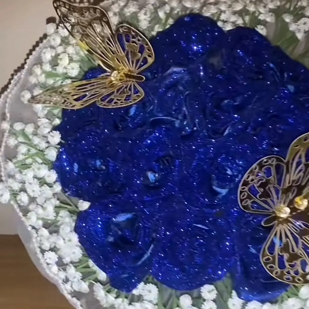 15 count navy glitter rose bouquet with babys breath rim and 2 gold butterflies and white mesh wrapping