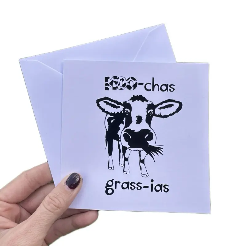 Handmade thank you card. Features a black gow eating grass with the slogan ‘Moo-chas grass-ias’