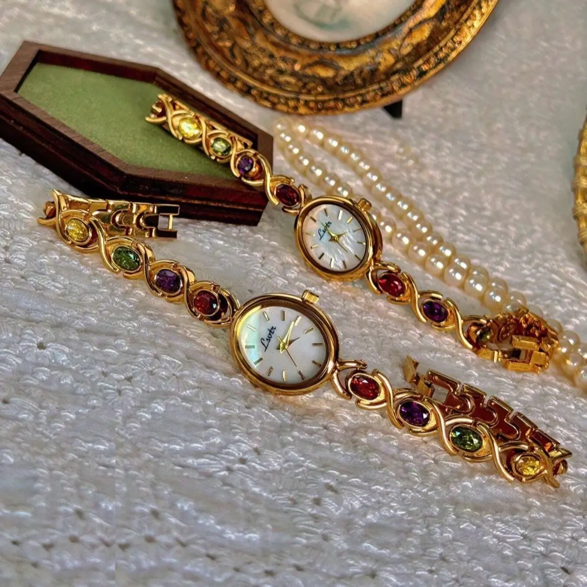 Womens vintage gold watch embedded with colourful diamonds and a pearl dial