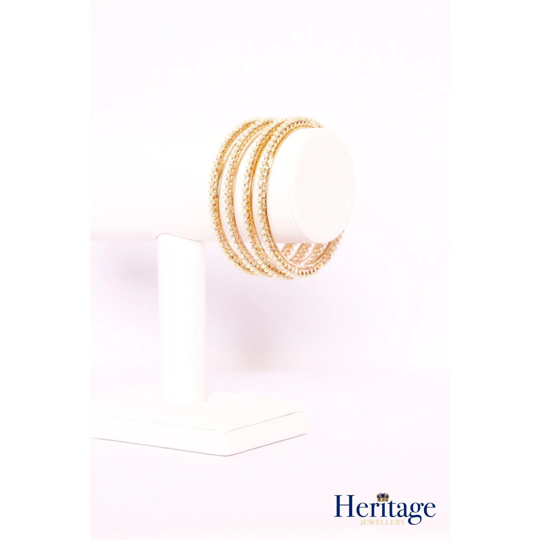 Rose gold bangles adorned with silver crystals and pearls.